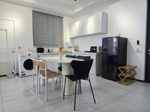 JelutongにあるVanilla Cottage - Urban Suites by Ocean Luxeのテーブルと椅子と冷蔵庫のあるキッチン