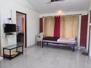 a bedroom with a bed and a tv in a room at Bramhagiri Resort in Lānja