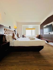 a large bedroom with a large bed and a television at Kanavu Valley View in Ooty