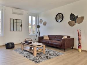 a living room with a leather couch and a coffee table at Appartement spacieux et lumineux proche gare in Ambérieu-en-Bugey