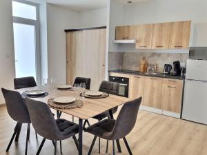 a dining room table with chairs and a kitchen at Appartement spacieux et lumineux proche gare in Ambérieu-en-Bugey
