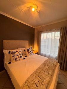a bedroom with a large bed and a window at Centurion La Creme Apartments in Centurion