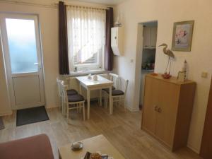 a living room with a small table and a window at Bungalow Alms in Ribnitz-Damgarten +5 photos