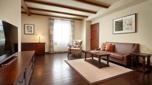 Lotte Arai Resort في ميوكو: غرفة معيشة مع أريكة وطاولة