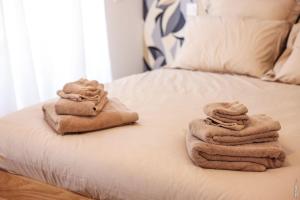 a pile of towels sitting on top of a bed at N1 L'Ecume de Montaudry - Terrasse - Parking in Albi
