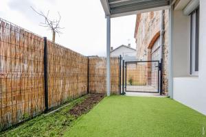 an internal courtyard with a fence and grass at N1 L'Ecume de Montaudry - Terrasse - Parking in Albi