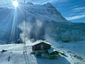 a ski lodge in the snow with a mountain at Hotel Bodmi in Grindelwald