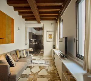 a living room with a couch and a tv at Palazzo Delle Pietre - Luxury Apartments in Rome