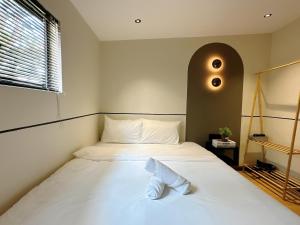a bedroom with a white bed with a large window at The Jubilee Guest House in Ipoh +13 photos
