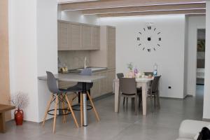 a kitchen with a table and chairs and a clock on the wall at Casa vacanze Martinclà in Trani