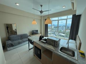 a room with a kitchen and a living room at Sutera Avenue Kota Kinabalu City Centre LW Suites in Kota Kinabalu