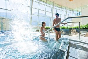 a man and a woman standing in a water fountain at Seeappartement Kitzsteinhorn in Zell am See