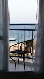 - un balcon avec une chaise et une table donnant sur l'océan dans l'établissement Avrora Luxury Apartment, à Ashkelon