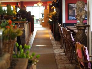 ein langer Gang in einem Restaurant mit Tischen und Stühlen in der Unterkunft Torhaus Möhnesee in Möhnesee