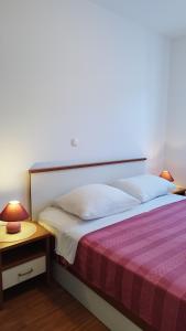 a bedroom with a bed with a red and white blanket at Apartmani Adriatica 2 in Dramalj +39 photos