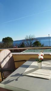 a table with a flower in a vase on a roof at Apartmani Adriatica 2 in Dramalj