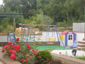 a child playing in a playground with a swing at Apartmani Adriatica 2 in Dramalj