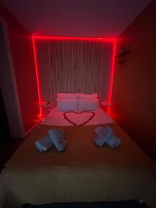 a bedroom with a bed with red lights at L'Amazonia in Croix