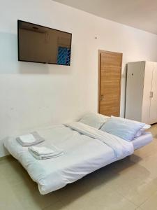 a white bed with a flat screen tv on the wall at Haifa boutique apartment by LIME in Haifa