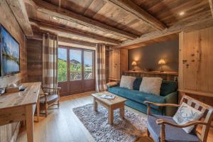 a living room with a blue couch and a table at Paccard Locations Chamonix in Chamonix-Mont-Blanc