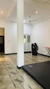 a room with a black rug and a white wall at COCO Rooms in Galle