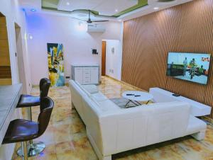 a living room with a white couch and chairs at Domicile Cotonou in Cadjèhoun