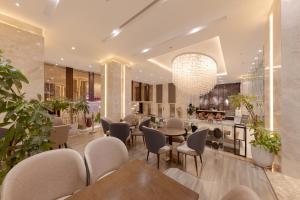 a restaurant with chairs and tables and a chandelier at Green Beach Hotel Nha Trang in Nha Trang