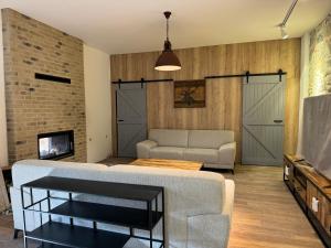 a living room with a couch and a tv at Villa MILIA in Bátovce