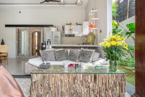 una sala de estar con un sofá y una mesa en Villa Thyme, Private 2BR pool Villa, 2 minute walking to cafe, padel and tennis court, en Canggu