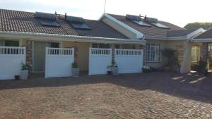 una casa con puertas blancas delante de ella en 93 On Main Self Catering, en Gonubie
