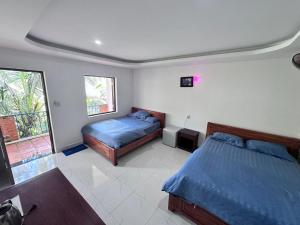 a bedroom with two beds and a window at AN THINH Hotel & Homestay in Bình Tú