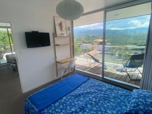 - une chambre avec un lit bleu et une grande fenêtre dans l'établissement Via Mare - Apt avec splendide vue, à Grosseto-Prugna 24 autres photos