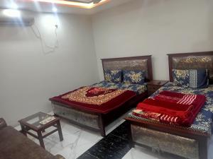 ein Schlafzimmer mit zwei Betten und einer Couch in der Unterkunft Four Season Guest House in Islamabad + 9 Fotos