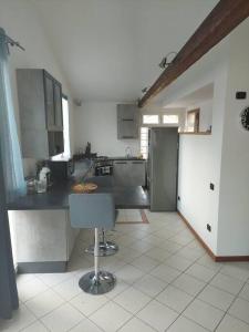 a kitchen with a counter and a chair in it at Luminoso LOFT in centro a due passi da Lugo Imola in Massa Lombarda