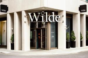 曼彻斯特Wilde Aparthotels Manchester City Centre的前面有白色标志的建筑