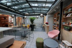 a room with tables and chairs and a room with books at H Complutum in Alcalá de Henares