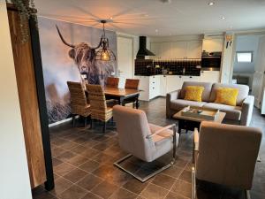 a living room with a table with a picture of a bull at Appartement De Graanzolder aan Zeeuwse kust in Hoofdplaat