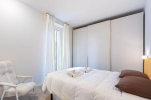 a bedroom with a white bed and a chair at Casa Pertinace in Alba