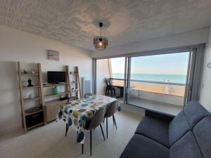 a living room with a table and a view of the ocean at Très bel appartement accès direct sur plage, vue sur mer - 2 pièces - 4 pers in Saint-Jean-de-Monts