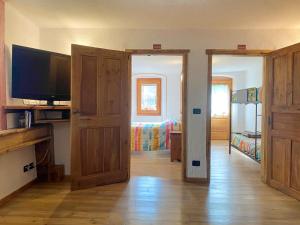 een kamer met een televisie en een kamer met een slaapkamer bij La corte del meleto - appartamento in stile Valdostano in Saint-Pierre