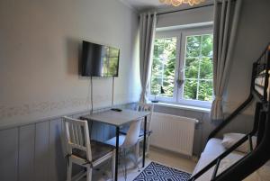 une pièce avec une table, des chaises et une fenêtre dans l'établissement Willa Szyszka, à Karpacz