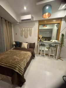 a bedroom with a bed and a table and a mirror at Cozy Place with City View at Greenbelt Makati in Manila