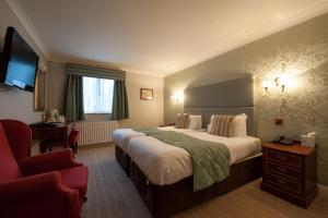 ein Hotelzimmer mit einem großen Bett und einem Schreibtisch in der Unterkunft The Minster Hotel in York
