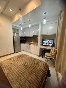 a living room with a kitchen with a television at Cozy Place with City View at Greenbelt Makati in Manila