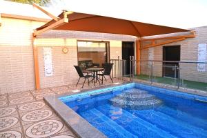 a swimming pool with a table and chairs next to a house at شاطئ العرب الرايس in Rayyis +43 photos