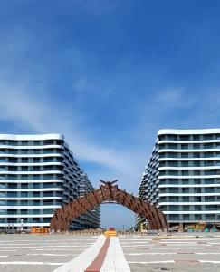 Dos edificios altos con una escultura en el medio. en Studio 60 By The Beach Mamaia, FREE PARKING Casa del Mar, en Mamaia
