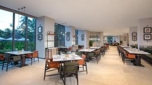 a dining room with tables and chairs and large windows at Holiday Inn Resort Sanya Bay by IHG in Sanya