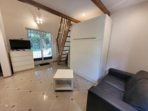 a living room with a couch and a tv at Le CHALET in Créteil +2 photos