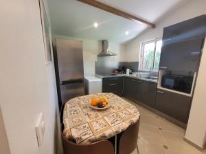 a kitchen with a table with a bowl of oranges on it at Le CHALET in Créteil