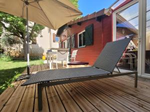 a chair and an umbrella on a deck at Le CHALET in Créteil